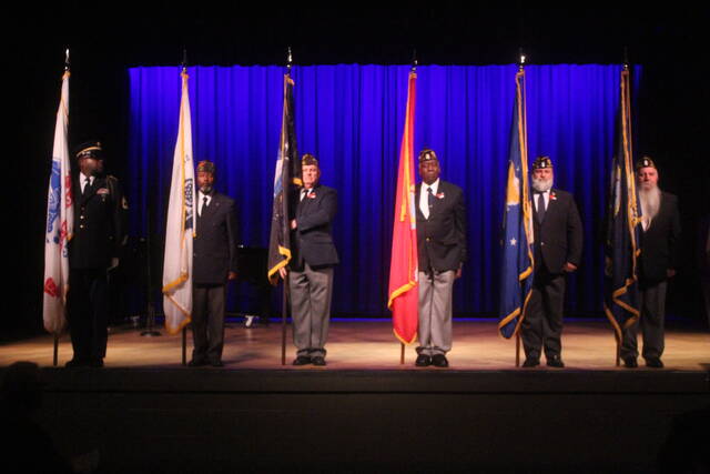 Flags representing each military branch are brought out onstage. 
                                 Noah Britt | Sampson Independent