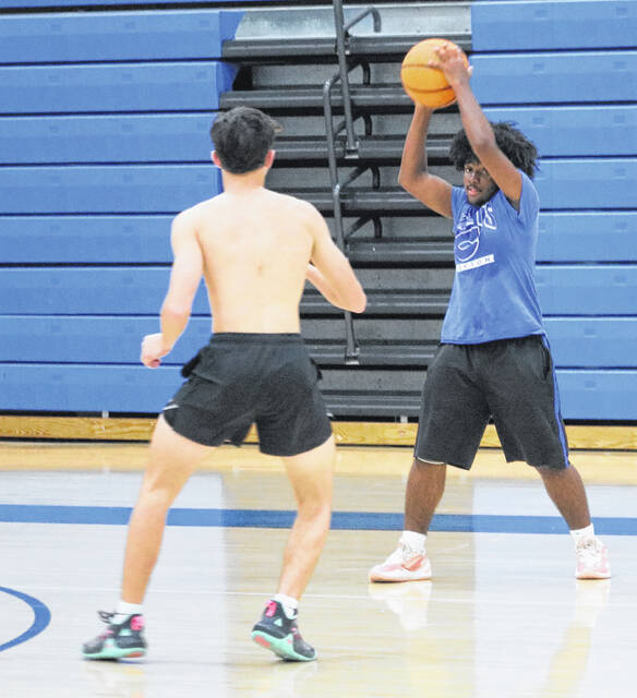 Midways Ace Matthews works on defense against Johnny Locklear, who surveys the court to make a pass.