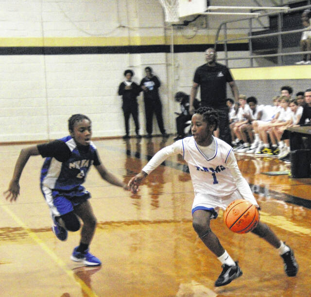Clinton guard TyMarion Stacker attempts to drive past defending Raider JaSiyen Cash.