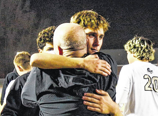 Coach Brad Spell embracing senior Dark Horse Cullen Brewer, as the emotions of the outcome start to hit the team.