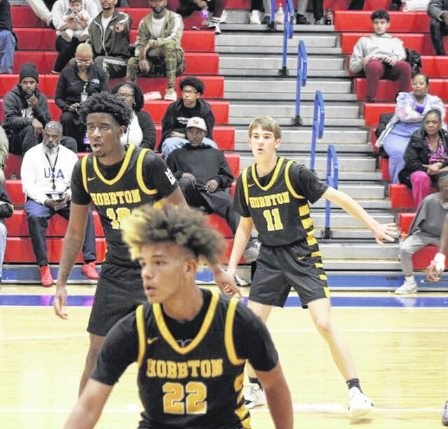 Idarius Eason (22), Richard Simpson (10) and Lathan Warren (11) set up in their zone defense during their away game Wednesday against at Western Harnett.