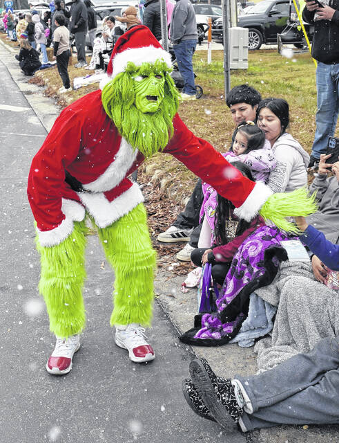 It might have been cold and a bit misty Saturday throughout Sampson County, but it didnt stop Newton Grove from kicking off Christmas in grand style with its annual parade, which drew a bundled up crowd to the circle and parts of the downtown to watch the colorful floats sweep through town. Pictured, a Dunn Clown gives a youngster a fist bump while the Grinch steals a fist bump; the Hobbton High Band plays some holiday music for the crowd; the Sudan Street Racers delight parade-goers and, of course, Santa makes his appearance as the parade closes out.
