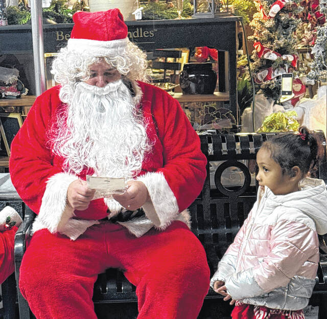 Santa readsa letter given to him by Giahana Deleon of Ingold during Saturday nights tree-lighting event in Garland.