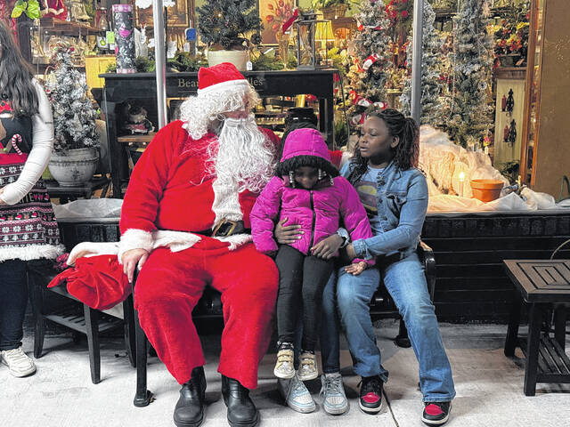 Santa talks with Garland youngsters Heavenly McCoy, Onett Karr, and Sadie Munn during Saturdays tree lighting.