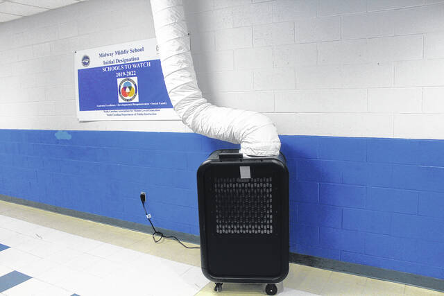 One of the new HVAC units stand in the hallway of Midway Middle School, pumping warm air into the vents while the schools heating system remains down.
                                 Photo by Noah Britt | Sampson Independent