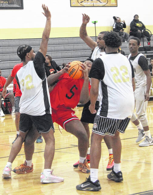 A group of Dark Horses swarm a Spartan alum to force a turnover, preventing a basket.