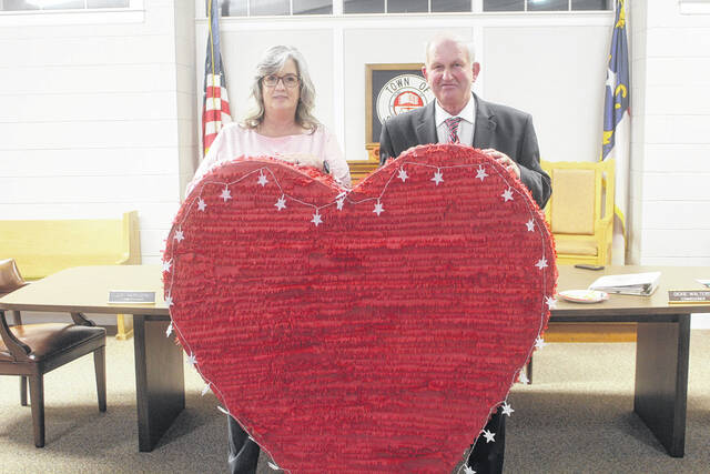 Salemburg Town Clerk Teresa Smith, left, and Mayor Joe Warren grin from behind the heart that will be lowered form the town hall building come New Years Eve.
Noah Britt | Sampson Independent