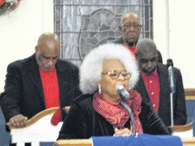 The Rev. Eloise Godwin speaks to the audience moments before prayer time, as members of the Lisbon Street Missionary Baptist Churchs Choir stand behind prepared to sing.
                                 Trevon McGlone| Sampson Independent