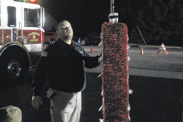 Salemburg Commissioner Joel Faircloth hooks up the titular heart to the Salemburg Fire Truck, preparing for its slow descent.
                                 Photos by Noah Britt | Sampson Independent