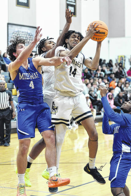 Clintons Taylen Moore secures a rebound over junior Raider Tanner Williams.
                                 Mike Carter | Sampson Independent