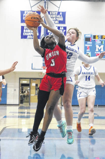 Junior Lady Spartan Centavia McKoy goes up against Ella Clark, looking for a basket.