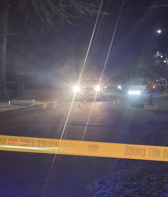 The bright blue and white lights from Clinton police cruisers spotlight yellow markers showing where bullet casings were found Monday night. It is believed to be the scene of a shooting that sent two men to the hospital with gunshot wounds.