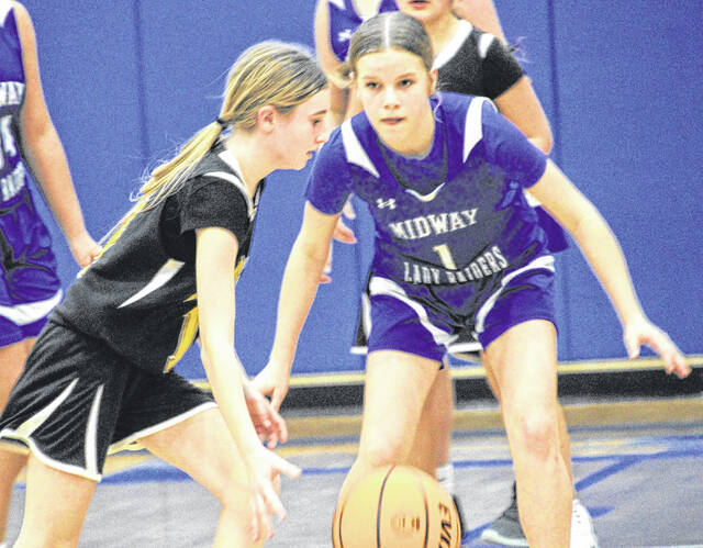 Lady Wildcat Aubree Simmons being tightly guarded by Midway guard Emery Williams.