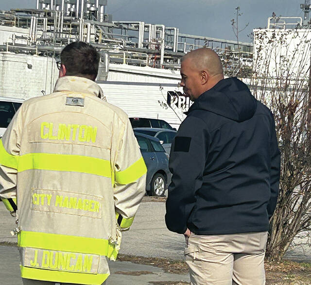 Clinton City Manager J.P. Duncan, left, and Police Chief Adrian Mathews have a discussion at the scene of a waste spill.
                                 Abby Cavenaugh | Sampson Independent