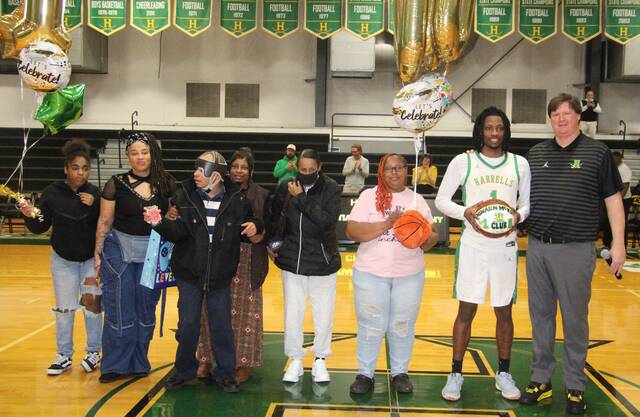 Harrells senior Dashaun McKoy, joined by family, receives his commemorative ball for surpassing 2,000 career points.