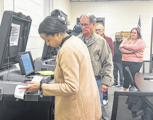 Sampson Board of Elections director Niya Rayor and Elections board member Dwight Williams review and sign off on absentee and early voting tapes Tuesday night while waiting for precinct volunteers to return from polling places across the county. (Abby Cavenaugh|Sampson Independent)