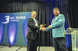 Newly elected N.C. Pork Council President Josh Coombs of Clinton, left, received the gavel from outgoing president Jay Archer.