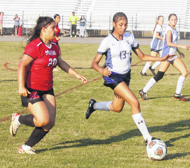 Senior Lady Spartan Marlene Sanchez and East Bladens Avianna Whittington dart to the ball as they battle for possession.