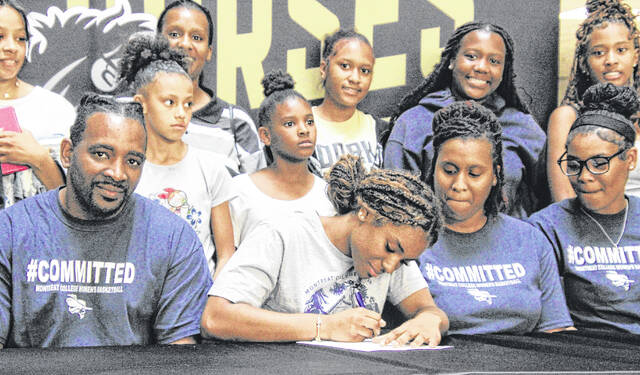 Janiya Mosley, surrounded by family, signs her letter of intent to play for Montreat College.