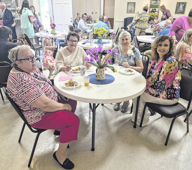 Ruth Ann Cantrell, Ann Knowles, Gloria Peterson and Kay Boyette are all smiles as they pose for a photo, their plates laden with baked goods.