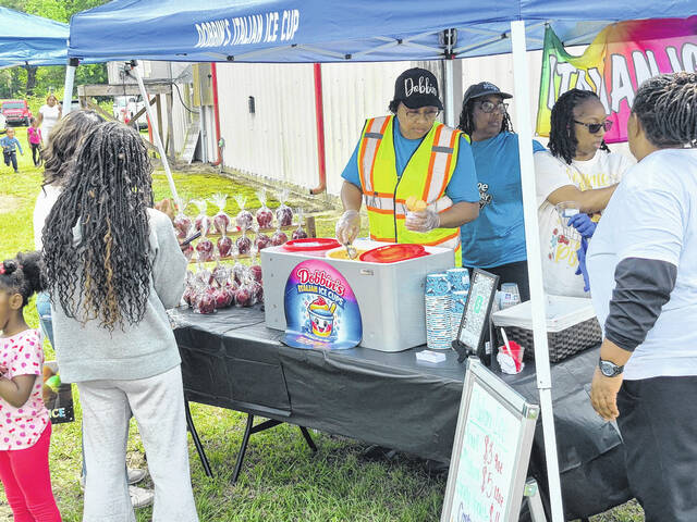 Event organizer Tiffany Dobbin operates the Devanes Italian Ice booth at Community Day, serving up frozen treats for the young and young at heart.