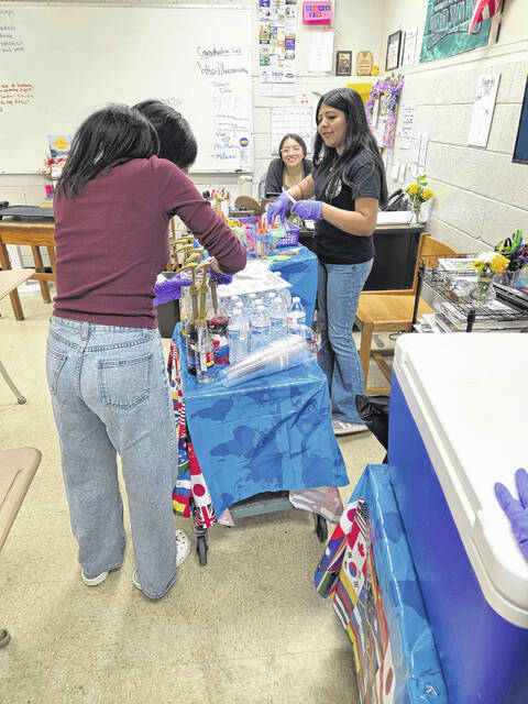 Lakewood High School World Language Development teacher Yadiraliz Hawks watches two of her students from the International Club carry around one of the carts from their refresher cafe.
Courtesy Photo| Vevlyn Lowe