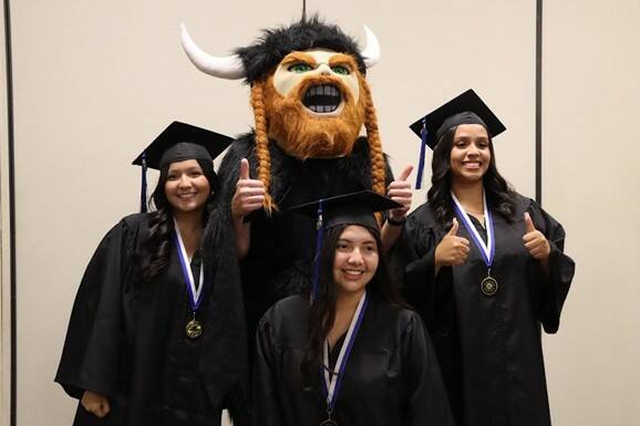 Soon-to-be SCC graduates pose with the Viking before their graduation ceremonies.