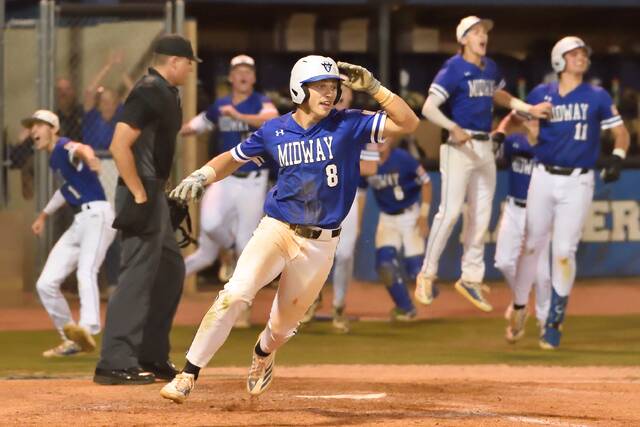 Midway junior Tanner Williams crosses the plate with the game winner as his teammates begin to celebrate their berth to regionals