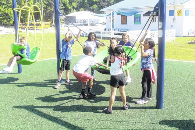 During the event, Clement students took advantage of the nearby playground. Here a group of students play on the swing.