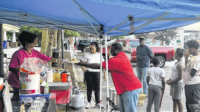 State of Opportunity NC members Celeste Bilbury, Tamika Mitchell and Candace Smith (all on the left) hand out food plates to paying customers.
                                 Trevon McGlone | Sampson Independent