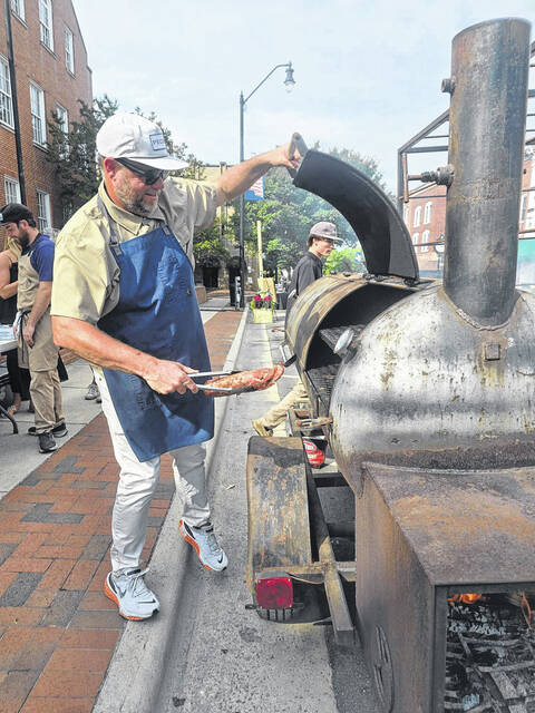 Matthew Register, Southern Smoke owner and chef, prepares to put another piece of tenderloin on the grill. That tenderloin, drizzled with a blueberry chutney, was the other entree served up to Dinner on Main guests. (Sherry Matthews|Sampson Independent)