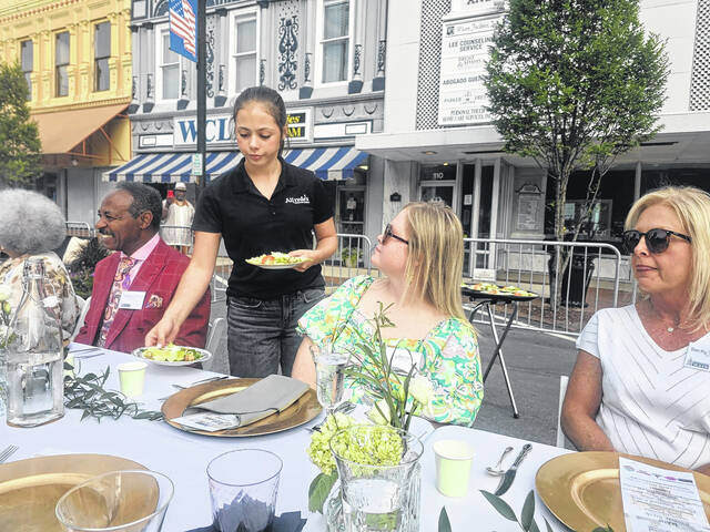 Caesar salads prepared and served by the Alfredos of Clinton staff delighted guests who shared a communal table that stretched down Main Street. (Sherry Matthews|Sampson Independent)