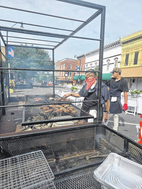 Deb Arche, chef at Ribeyes of Clinton, checks the beef sizzling on a hot grill Sunday afternoon just an hour or so before that beef would be served up as one of the main entrees during Dinner on Main. (Sherry Matthews|Sampson Independent)
