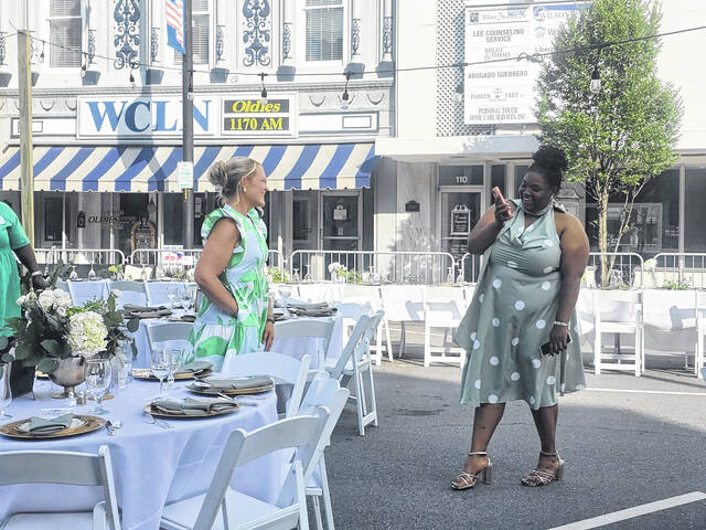 Clinton Main Street Director Tyler Wise, right, videos Meredith Horne, Main Street committee member, for a social media post hyping up the historic and first-ever Dinner on Main Sunday night. (Sherry Matthews|Sampson Independent)