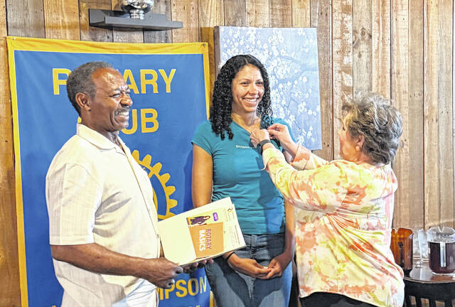 Clinton-Sampson Rotary President Thaddeus Godwin offers a joyous welcome to new member Keara Mitchell of KCI Homebuyers in Clinton, center, as her Rotary sponsor, Sherry Matthews, Sampson Independent publisher, awards her a new member pin during installation ceremonies June 1 during the clubs noon day meeting. Mitchell said she decided to join the noon day club because of their focus on local service projects, love of community and strong fellowship.