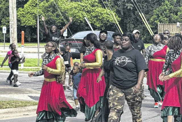 Members of The Restoration Church parade through the streets of Clinton during the Juneteenth parade Saturday morning.
                                 Trevon McGlone | Sampson Independent