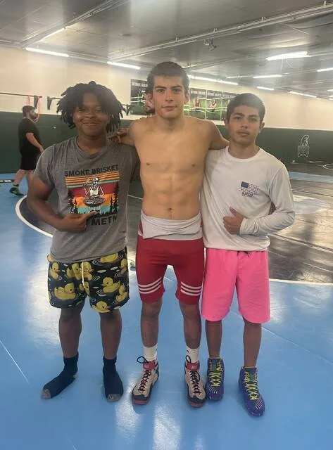 Rising junior Amoni Parker, along with Perrys sons Jaxon, center, and Wyatt at a wrestling camp at the University of Mount Olive. Jaxon Perry is a senior who has qualified for nationals twice.