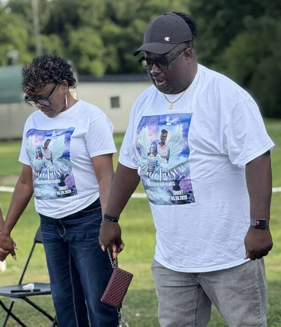 Bishop Eddie Parker, who officiated Annie Faisons funeral, along with Elder Angela Holmes, bows for prayer during the vigil Saturday.