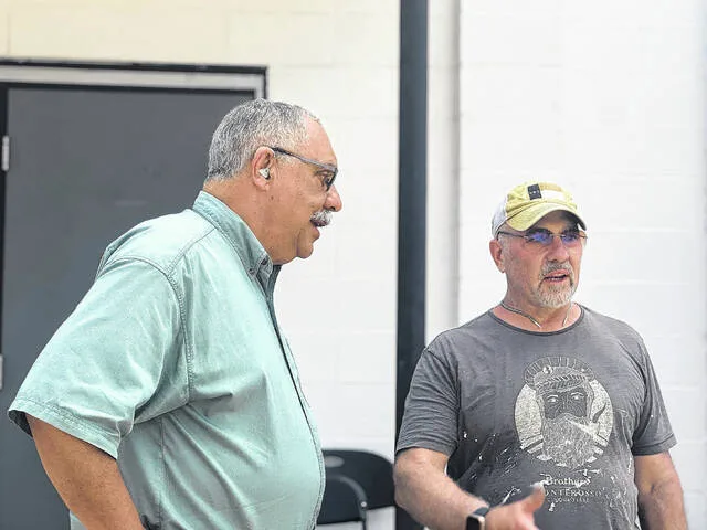 Paris Alexander, right, discusses the sculpture with Coharie Tribal member Greg Jacobs, left.