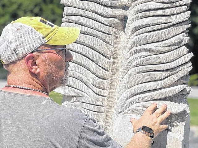 Sculptor Paris Alexander draws attention to the texture of the feather.