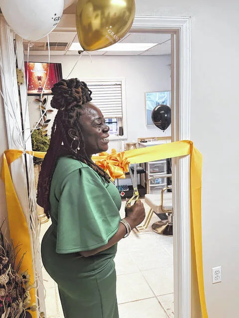 Marshell Boykin, founder of Protect The Crown, cuts the ceremonial ribbon to her new beautification salon.