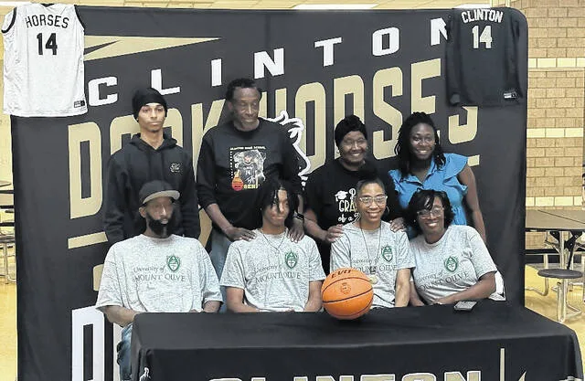 Taelyn Moore and his family pose for photos on his signing day announcement Tuesday at Clinton High School. Moore was a Dark Horse for all four years of his basketball career, averaging 7.9 points per game and 5.5 rebounds per game in his final year at Clinton High. Moore has decided to play for the University of Mount Olive.
Trevon McGlne | Sampson Independent