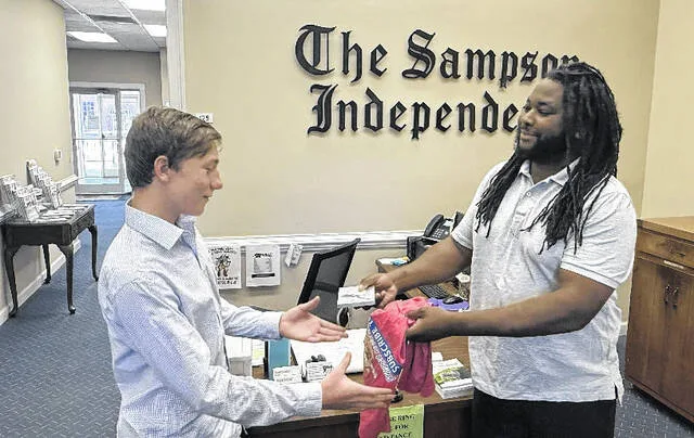 Sampson Independent Editor Anthony Goodman awards Caleb Bennett his prizes for his winner entry in the Sampson Independent America 250 coloring contest.
                                 Trevon McGlone | Sampson Independent