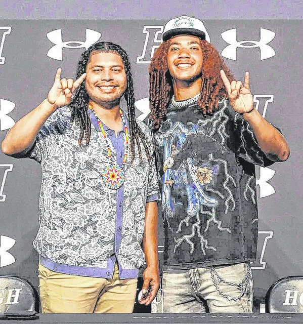 Ethan Royal, right, and his older brother Kris Royal put up the horns representing the Thundering Herd.