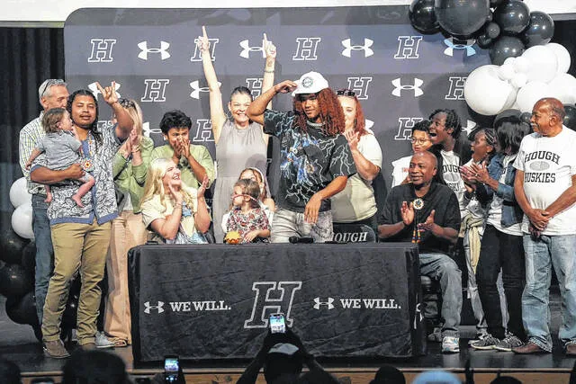 Clinton native Ethan Royal, a rising senior at Hough High School, officially makes his decision, dawning a Marshall cap, as his family celebrates.