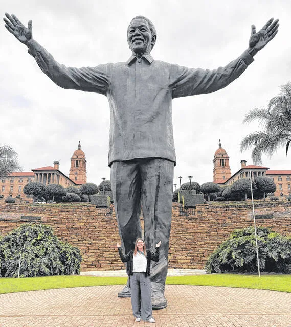 Raven Vaughn poses in front of a massive statue of former South Africa president and advocate Nelson Mandela.