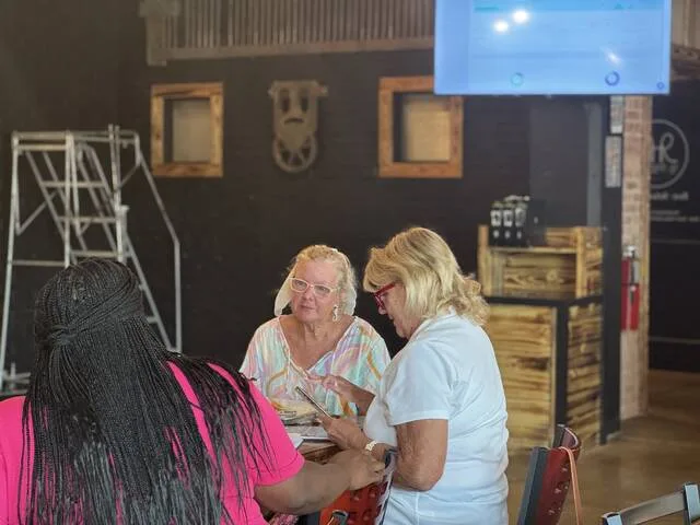 Tyler Wise, Wendy Dorman, and Debbie Roberts with the Main Street Committee watch ticket sales in real-time Saturday afternoon at the R&R Kitchen and Taproom for Septembers upcoming Low Country Boil happening on Vance Street.
                                 Dylan Atwood | Sampson Independent