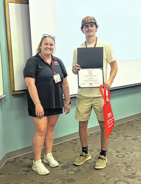 Luke Weeks receives a certificate during the closing program of PSSI. Each PSSI student must present to parents and stakeholders during the program about their experience.