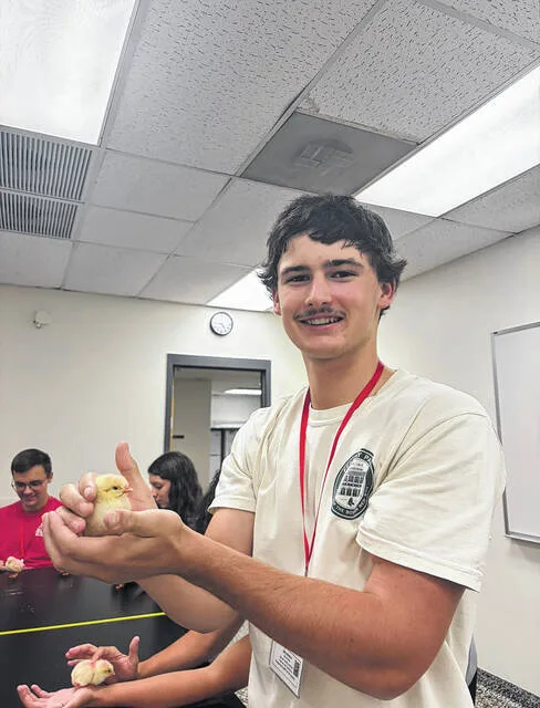 Luke Weeks holds a baby chick after the PSSI Embryology Lecture and Lab, where students learned about principles of incubation and the stages of incubation, with the lecture ending with real chicks.