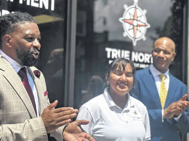 Antonio Glover, the director of operations for True North Medical Equipment and Supply in downtown Clinton, delivers a speech at the stores grand opening, as Karen Jimenez, the stores intake specialist, and Eric West, the director of business development, cheer him on. The medical equipment and supply store offers both new and refurbished medical equipment and supplies. Glover thanked all who helped make the new store possible, and stated that the staff is committed to providing aid for all families in need, especially those with lower incomes. They encourage walk-ins.
                                 Dylan Atwood | Sampson Independent